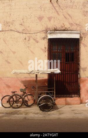 Pédicab (vélo taxi) dans une rue coloniale à Hunucma, Yucatan, Mexique. Les drapeaux de Papel Picado volent en hauteur. Banque D'Images