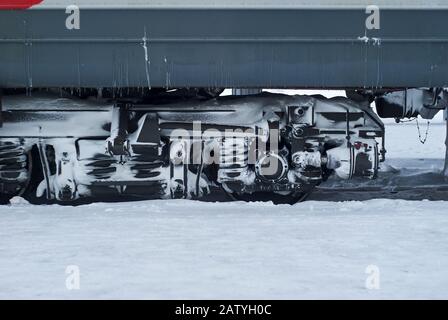 bogie recouverte de glace et de neige d'un transport ferroviaire de passagers sur rails pendant l'utilisation en hiver Banque D'Images