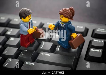 Tambov, Fédération de Russie - 24 janvier 2020 Lego homme d'affaires et femme d'affaires minibus debout sur un clavier d'ordinateur noir. Banque D'Images
