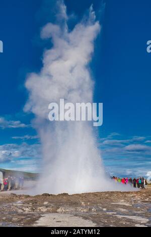 Haukadalur, Icleland - 28 septembre 2017: Strokkur qui déchue son eau à environ 20 mètres de haut, les touristes regardent le geyser Banque D'Images