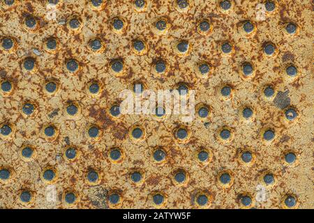 résumé jaune métallique peint rouille texture contenant un tableau de trous ronds Banque D'Images