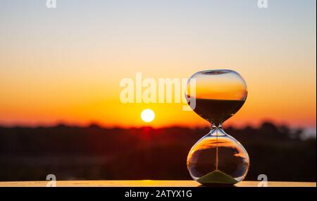 HourGlass au coucher du soleil ou à l'aube sur un fond flou, comme rappel de l'heure de passage Banque D'Images