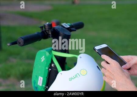 Brisbane, Queensland, Australie - 28 janvier 2020 : gros plan sur le guidon et le symbole de balayage d'un scooter électrique citron vert-S et d'un mobile à main Banque D'Images