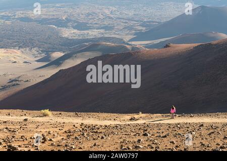 Un randonneur féminin solitaire regarde un paysage aride impitoyable. Banque D'Images