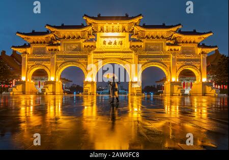 Les Touristes défier la pluie à la porte avant de Chiang Kai Shek Memorial hall à Taipei City, Taiwan Banque D'Images