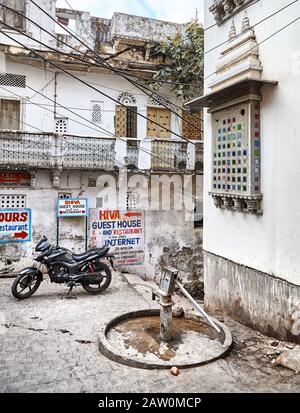 Udaipur, RAJASTHAN, INDE - 03 MARS 2015 : moto noire dans la rue étroite avec panneau d'affichage de Shiva dans la ville d'Udaipur. Banque D'Images