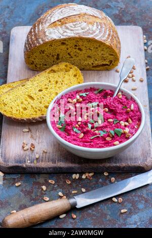 Houmous de betterave rôtie maison et pain de levain curcuma sur fond d'ardoise Banque D'Images