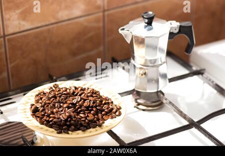 Grains de café sur une plaque et pot à café moka sur un poêle à gaz Banque D'Images