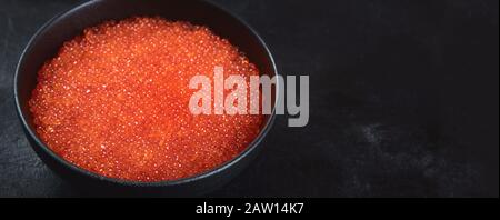 Œufs de saumon. Caviar rouge sur fond noir. Image avec espace de copie. Panorama, bannière Banque D'Images