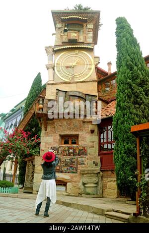 Voyageur Féminin Prenant Des Photos De La Tour De L'Horloge Penchée Créée Par Le Célèbre Gean Puppeteer Rezo Gabriadze, Vieille Ville De Tbilissi, Géorgie Banque D'Images