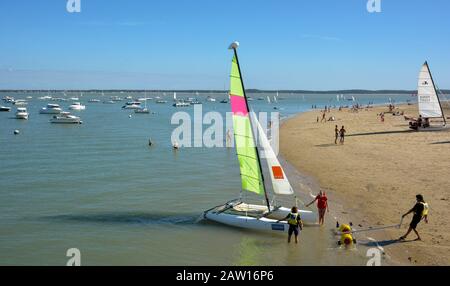 Les vacanciers lancent un catamaran. Plage St-Trojan, Ile d'Oléron France. Banque D'Images