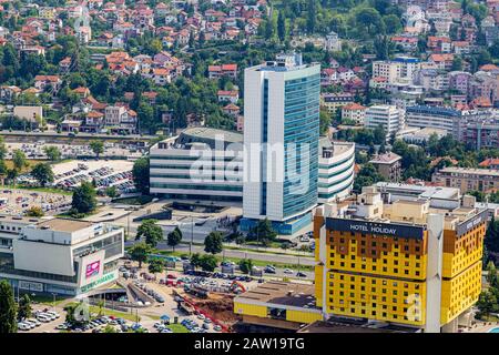 L'hôtel Holiday Inn, qui abrite des journalistes pendant la guerre, le "plus bombardé hôtel" en Europe. Derrière lui le bâtiment des Parlements.Sarajevo. Banque D'Images