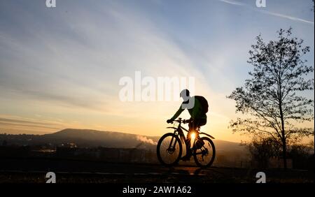 Stuttgart, Allemagne. 06 février 2020. Un cycliste se déplace dans un parc pendant que le soleil se lève derrière lui. Crédit: Sebastian Gollnow/Dpa/Alay Live News Banque D'Images