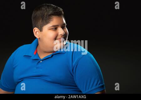 Portrait d'un garçon de chubby regardant sur le côté. (Obésité) Banque D'Images