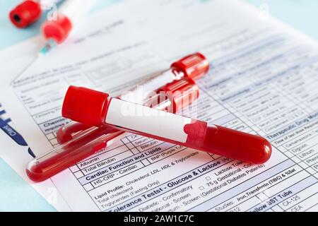 Flacon de sang rouge avec échantillon de sang sur fond de formulaire de test. Tube de test sanguin et forme de rapprochement des résultats. Banque D'Images