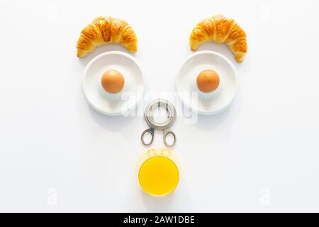 Petit déjeuner amusant avec un visage humain abstrait étonnement fait d'articles de petit déjeuner sur fond blanc Banque D'Images