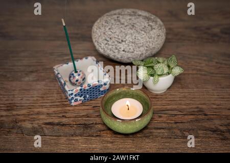 Autel de maison. Bougie brûlante dans un boîtier en céramique, des bâtons d'encens, des plantes en pierre et fraîches. Concept de pleine conscience, contexte de méditation. Style japonais zen h Banque D'Images