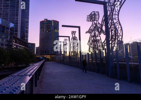 Histoire de l'immigration australienne et sculptures sur le pont ferroviaire Sandridge en soirée en été, centre-ville de Melbourne, Victoria, Australie Banque D'Images