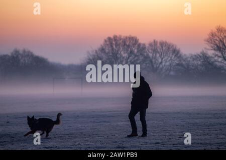 Northampton, Royaume-Uni, Weather, 6 février 2020, Frosty commence la journée pour un homme marchant son chien allemand de Shepard avec brouillard au sol et couleur de préaube dans le ciel à Abington Park. Crédit : Keith J Smith./Alay Live News Banque D'Images