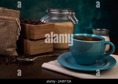 Tasse de sachets de café et de jute, récipients en bois remplis de fèves de cofée sur le fond de rouille. Sucre de canne. Banque D'Images