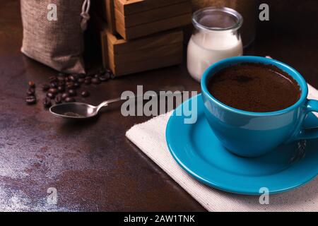 Tasse de sachets de café et de jute, récipients en bois remplis de fèves de cofée sur le fond de rouille. Sucre de canne. Faible luminosité. Banque D'Images