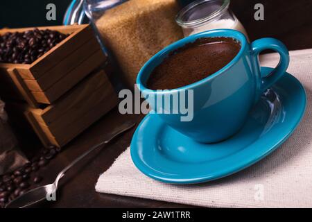 Tasse de sachets de café et de jute, récipients en bois remplis de fèves de cofée sur le fond de rouille. Sucre de canne. Faible luminosité. Banque D'Images