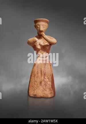 Figurine femelle en argile de Minoan dans l'attitude de culte, Chamezi 1900-1700 av. J.-C.; Musée archéologique d'Héraklion, fond gris. Banque D'Images