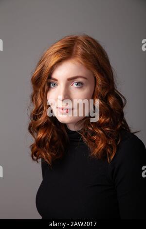 Portrait d'une belle femme à tête rouge regardant vers l'appareil photo. Banque D'Images