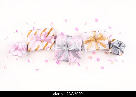 Ensemble de boîtes-cadeaux avec des arcs et des confettis sur un fond blanc. Banque D'Images