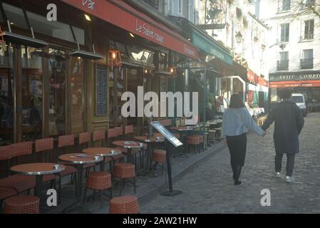 Un couple tenant les mains se promenant le long d'une voie pavée à Paris, pasakdek Banque D'Images