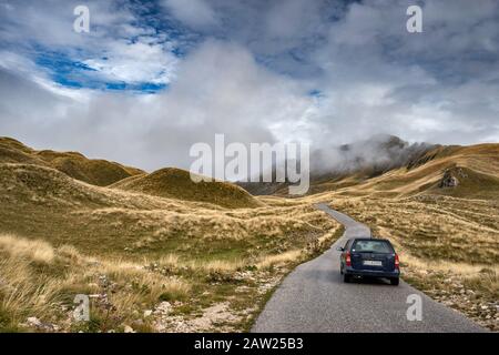 Véhicule sur route de montagne, hauts pâturages du plateau de Piva et montagnes de Durmitor dans le parc national de Durmitor, Alpes Dinaric, près de Zabljak, Monténégro Banque D'Images