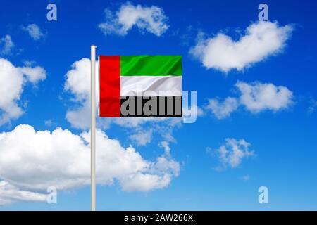 Drapeau des Émirats arabes Unis isse devant le ciel bleu nuageux, Émirats arabes Unis Banque D'Images