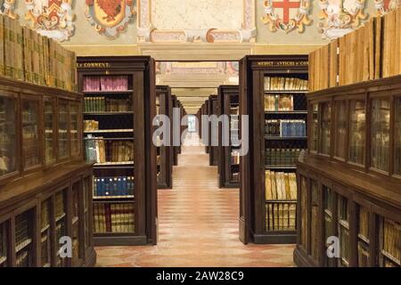 Ancienne bibliothèque avec étagères pleines de livres et couloirs interminables, disposées dans un ordre spécifié selon le système de classification de la bibliothèque. Banque D'Images