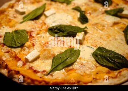 Trois pizzas au fromage à croûte mince fraîchement cuites avec des feuilles de basilic sur une table en bois gros plan Banque D'Images