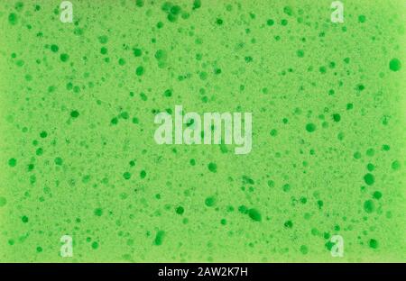 Fond de texture éponge. Vue rapprochée des détails de l'éponge de nettoyage de couleur verte. Lavage de vaisselle ou soins de beauté. Macro Banque D'Images