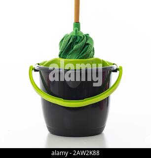 Nettoyage de la mop sur un seau de couleur noire verte isolée sur fond blanc, nettoyage domestique Banque D'Images