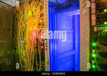 Les fils désordonnés sont connectés dans un rack de serveurs. Beaucoup de câbles sont entrelacés dans le centre de date de l'armoire informatique. Concept de technolog Internet moderne Banque D'Images