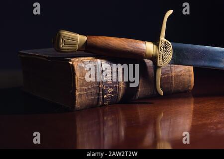 Épée ancienne à côté d'une ancienne Bible de 150 ans Banque D'Images