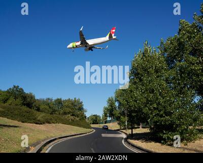 Avion de la société portugaise TAP, volant au-dessus d'une route près de l'aéroport de Lisbonne Portela, Portugal. Banque D'Images