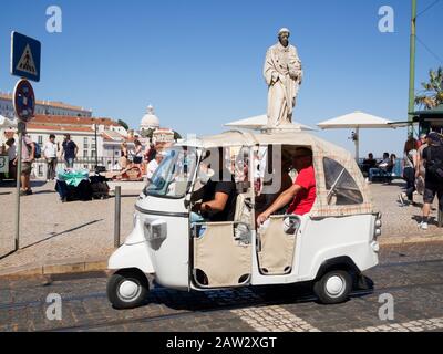 Les touristes qui voyagent à bord d'un véhicule Tuktuk pour des visites touristiques à Lisbonne, au Portugal Banque D'Images