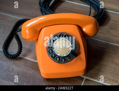 Téléphone orange vintage avec fond en bois Banque D'Images