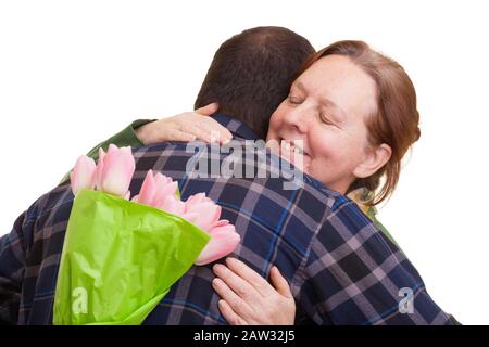 Homme avec bouquet de tulipes roses dissimulées derrière sa femme âgée embrassant le dos, isolée sur fond blanc. Fête des mères, Saint Valentin, Pâques et su Banque D'Images