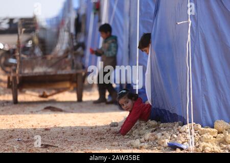 06 février 2020, Syrie, Ma'arrat Misrin: Un enfant syrien déplacé à l'intérieur de son propre pays s'enfuit d'une tente dans un refuge de fortune pour les familles qui ont fui Saraqib et Sarmin pour échapper aux opérations militaires en cours. Photo : Anas Alkharboutli/Dpa Banque D'Images