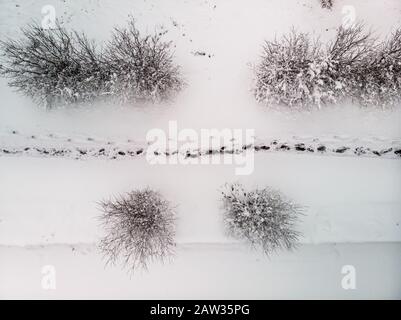 Photo aérienne d'un sentier enneigé avec des empreintes sur la neige en hiver. Bucarest, Roumanie Banque D'Images