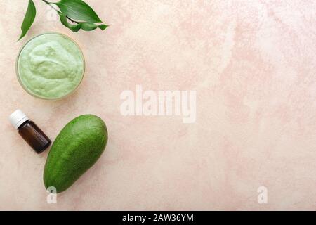 Masque de visage avocat dans un bocal en verre avec feuilles et avocat, huile. Masque nourrissant maison fait d'une purée d'avocat. Recette de cosmétiques maison de bricolage, peau Banque D'Images