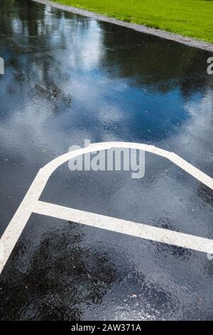 Lignes blanches dans un parking juste après une pluie Banque D'Images