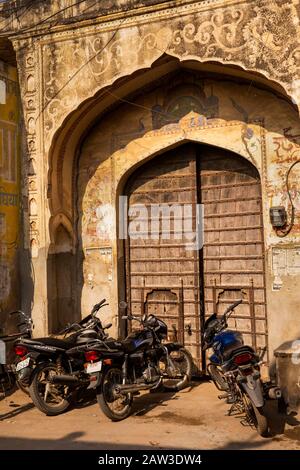 Inde, Rajasthan, Shekhawati, Mandawa, motos stationnées à l'extérieur de la porte historique en bois hablei Banque D'Images