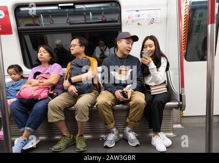 Hong Kong Lifestyle; Hong Kong Mass transit Railway - les gens locaux assis dans un intérieur de transport, Hong Kong MTR, Hong Kong Asie Banque D'Images