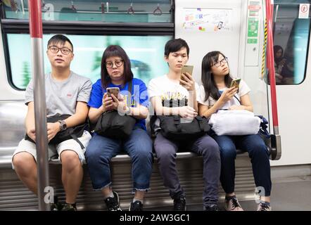 Hong Kong Lifestyle; Hong Kong Mass transit Railway - les gens locaux assis dans un intérieur de transport, Hong Kong MTR, Hong Kong Asie Banque D'Images