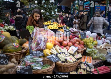 Londres, Royaume-Uni, - 23 - décembre 2019, Différents types de légumes et de salades au comptoir du marché Borough. Intérieur d'un magasin de légumes. Client lo Banque D'Images